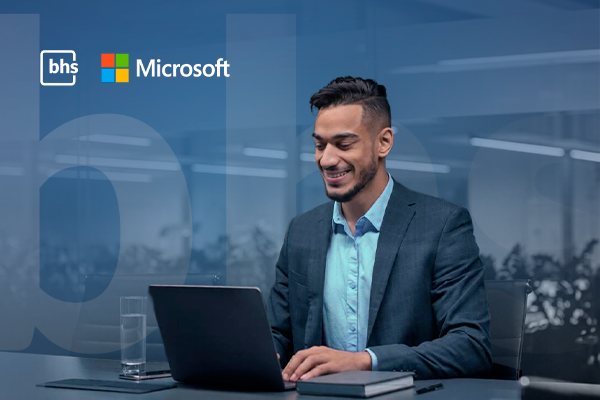 Profissional de TI trabalhando em notebook com as logos da BHS e Microsoft ao fundo, representando a gestão de licenciamento Microsoft 365